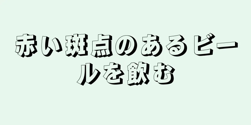 赤い斑点のあるビールを飲む